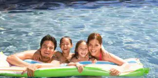 A Hispanic family swimming in a pool and enjoying McAllen living.